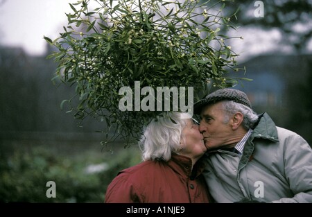 Ein paar küssen unter eine Handvoll Mistel in Leominster Holly und Mistel-Auktion Stockfoto