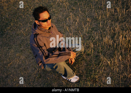Kniender Mann mit Sonnenbrille Stockfoto