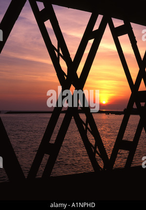 Barmouth Brücke Sonnenuntergang Blick durch Stahlträger Hafen im Hintergrund Gwynedd Mid Wales UK Stockfoto