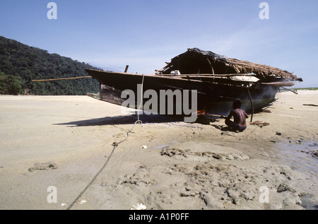 ein Feuer anzündet, unter dem Boot Tonhöhe zu schmelzen, die wird verwendet, um auf das Holz zur Abwehr wühlen Würmer und Krabben antifouling Stockfoto