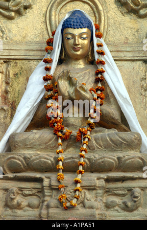 Eine Buddha-Statue ist mit einer Blumengirlande in der Nähe der Mahabodhi-Tempel in Bodhgaya in Bihar in Indien eingerichtet. Stockfoto