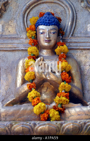 Eine Buddha-Statue ist mit einer Blumengirlande in der Nähe der Mahabodhi-Tempel in Bodhgaya in Bihar in Indien eingerichtet. Stockfoto