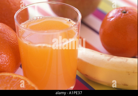 Glas frisch gepressten Orangensaft mit Früchten im Hintergrund Stockfoto