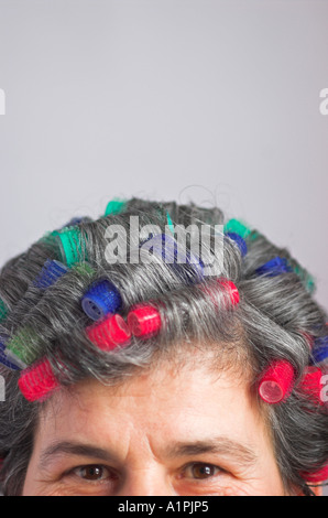 Reife Frau mit Lockenwickler Stockfoto