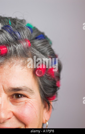 Reife Frau mit Lockenwickler Stockfoto