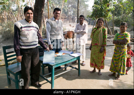 Männer, die das Geld von TeilnehmerInnen in einem Mikro-Kredit-Darlehen-Programm im nördlichen Bangladesh Stockfoto