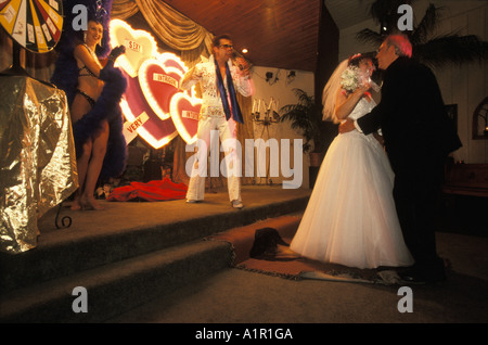 Ein Elvis-Imitator singt für frisch vermählte Paar, während sie auf ihre Themen Elvis-Hochzeit in Las Vegas Nevada USA tanzen Stockfoto