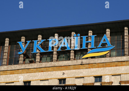 Kiew-Gebäude mit „Україна“-Schild, das den nationalen Stolz der Ukraine vor einem klaren blauen Himmel symbolisiert. Stockfoto