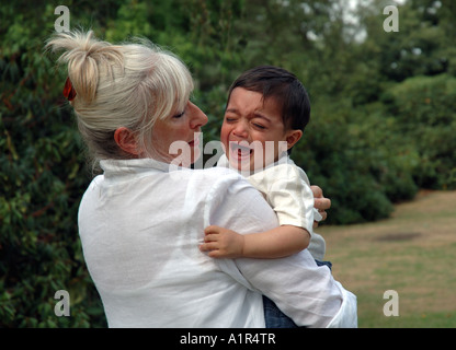 Großmutter tröstlich schreiendes Kleinkind. Stockfoto