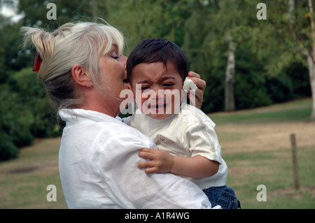 Großmutter tröstlich schreiendes Kleinkind. Stockfoto