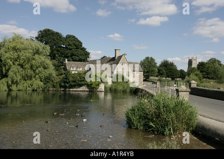 Die alte Mühle am Fluss Coln am Fairford mit seiner feinen Cotswold Wolle Kirche. Stockfoto