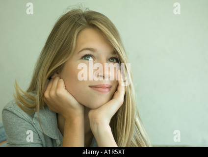 Junge Frau Kopf in Händen ruhen und wegsehen Stockfoto