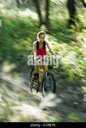 Mädchen reiten Mountain Bike Downhill im Wald, verschwommen Bewegung Stockfoto