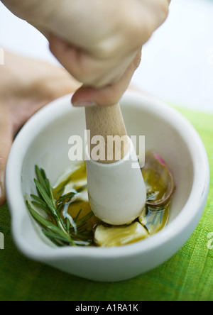 Knoblauch und Kräuter gemischt mit Olivenöl mit Stößel Stockfoto