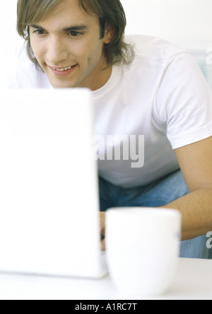 Mann mit Kaffeetasse mit laptop Stockfoto