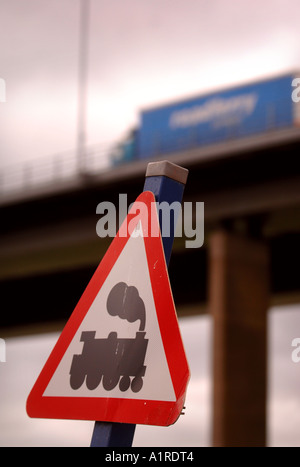 EINE EISENBAHN KREUZUNG WARNSCHILD MIT EINES SATTELSCHLEPPERS VORBEI IN DEN HINTERGRUND Stockfoto