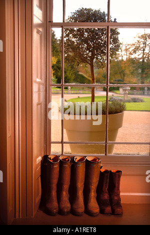 GUMMISTIEFEL IN DER VORHALLE EIN HERRENHAUS IN DER NÄHE VON CHELTENHAM GLOUCESTERSHIRE UK Stockfoto