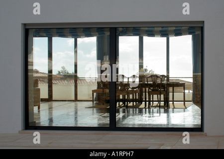 Hause mit Esszimmer Blick von außen durch die Fenster benachbarten Haus Reflexion gesehen Ambient modernist Stockfoto