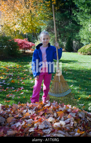 Kind Laubrechen im Hinterhof Stockfoto