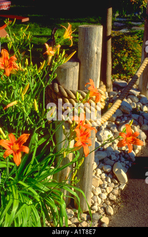 Tiger-Lilien wachsen im Garten neben dem Seil und post nautischen Motiv. Door County, Wisconsin WI USA Stockfoto