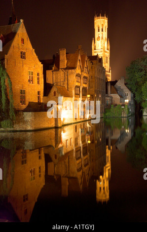 Eine nächtliche Szene der mittelalterlichen Stadt Brügge mit Glockenturm sich in den Kanal perfekt wider. Stockfoto