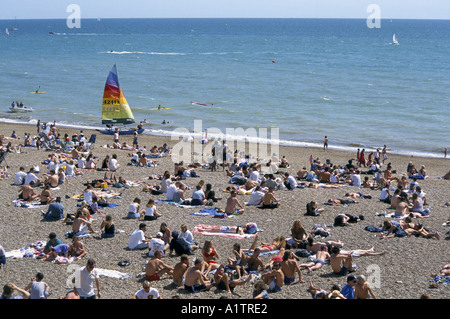 Szene auf BRIGHTON Strand Juli 1995 mit Windsurfen Boot und Sonnenanbeter Stockfoto