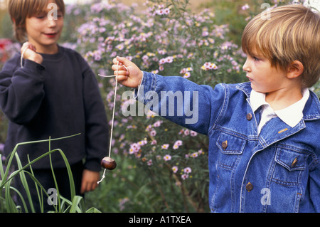 ZWEI JUNGS SPIELEN CONKERS ALTER VON 7 UND 4 1995 Stockfoto