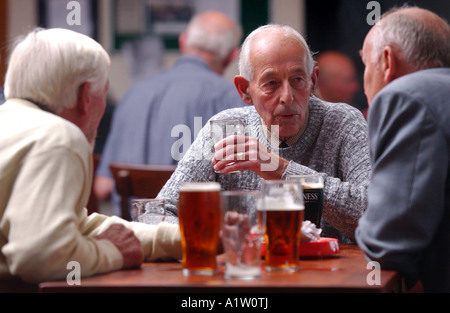 drei ältere Herren sprechen und trinken in einer Kneipe Stockfoto
