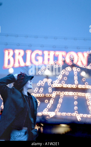 Frau mit Hut genießen Besuch in Brighton Palace Pier trotz Winterregen Stockfoto