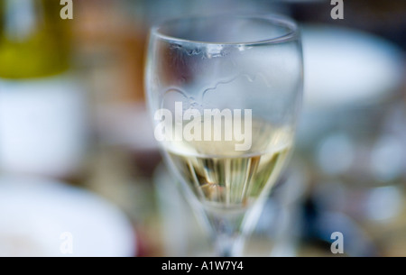 Halb volles Glas Weißwein auf Sommer Tabelle flachen Schärfentiefe nass Mark Lippen Rand Stockfoto