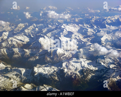 hoch in den Himmel fliegen Wolken-Formationen, die Höhe aus einem Flugzeug-Fenster von oben gesehen über THE ALPES Berg Tal Schneedach Stockfoto