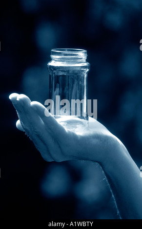 Mans Hand mit einem leeren Glas, draußen bei Tageslicht. Stockfoto