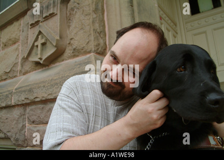 Yvan Tessier und sein sehendes Auge Hund auf Stufen des Univeristy of New Brunswick Gebäude Stockfoto