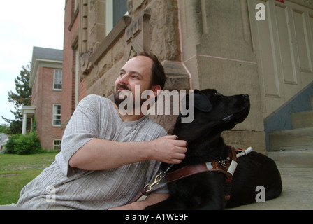 Yvan Tessier und sein sehendes Auge Hund auf Stufen des Univeristy of New Brunswick Gebäude Stockfoto