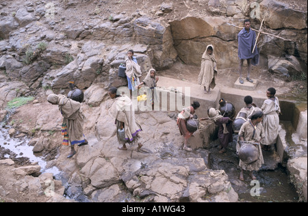 GROßE GRUPPE VON FRAUEN SAMMELN VON WASSER AUS EINER QUELLE. ÄTHIOPIEN 1998 Stockfoto