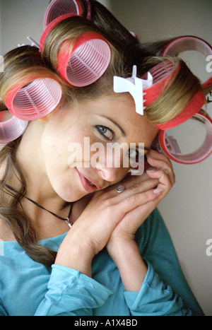 Junge Frau in Lockenwickler Stockfoto