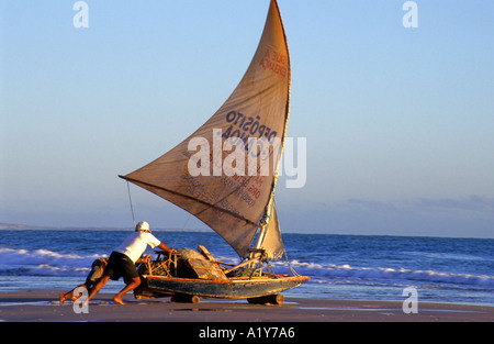 Fischer herausschieben sein Boot auf das Meer, Canoa Quebrada Strand, Ceara, Nordost-Brasilien Stockfoto