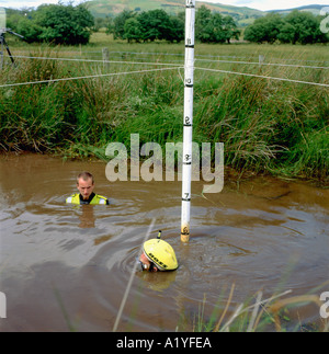 Ein Teilnehmer versenkte sich unter Wasser mit Helm, der in der Mountainbike-Moor-Schnorchelmeisterschaft Llanwrtyd Wells Wales UK UK KATHY DEWITT sichtbar war Stockfoto