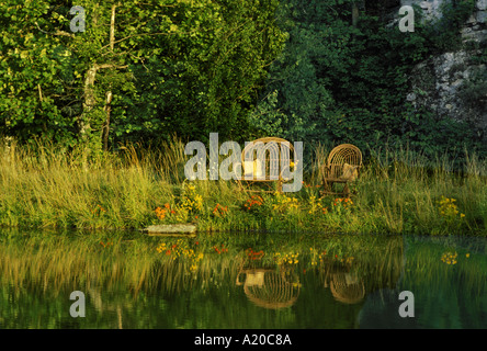 Friedliche Szene: Handgefertigte gebogene willow Stuhl neben ruhigen See in See am Abend noch Licht reflektiert, Missouri, USA Stockfoto