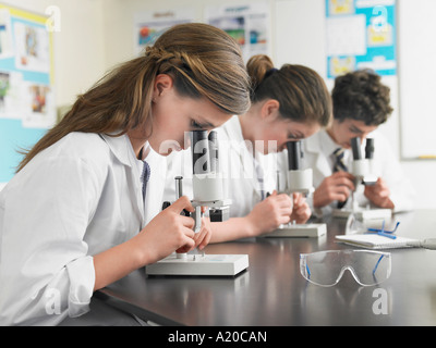 Schülerinnen und Schüler mit Mikroskopen im Klassenzimmer Stockfoto