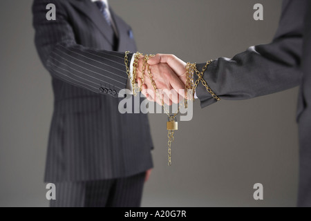 Geschäftsleute Händeschütteln eingewickelt in gold Kette mit Vorhängeschloss, Mittelteil Stockfoto