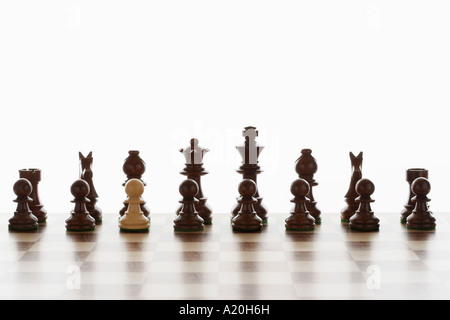 Einzelne weiße Bauer in erste Line-up von schwarzen Schachfiguren Stockfoto
