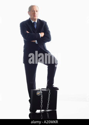Geschäftsmann mit Fuß auf verkettete Aktentasche Stockfoto
