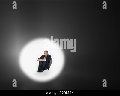 Geschäftsmann, sitzen im Rampenlicht Stockfoto