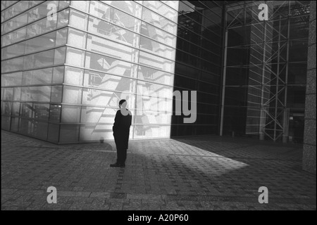 Ein Mann steht im Schatten außerhalb ein modernes Bürogebäude, Tokyo, Japan Stockfoto