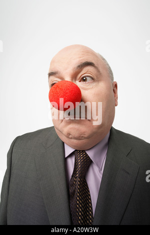 Glatze Businessman Wearing Clownsnase, runzelt die Stirn Stockfoto