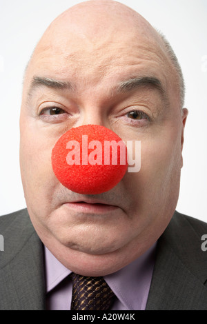 Glatze Businessman Wearing Clownsnase, stirnrunzelnd, Nahaufnahme Stockfoto