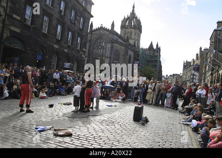 Straßentheater-Darsteller unterhalten Touristen in der Royal Mile High Street während der jährlichen International Arts Festival, Edinburgh. Stockfoto