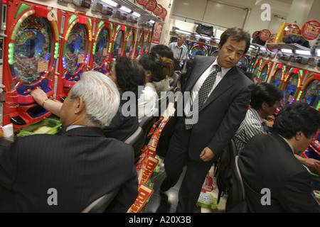 Japanische Spieler spielen die beliebten Pachinko Spielautomaten im Espace Nittaku Pachinko Salon, Tokio, Japan. Stockfoto