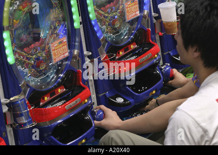 Japanische Spieler spielen die beliebten Pachinko Spielautomaten im Espace Nittaku Pachinko Salon, Tokio, Japan. Stockfoto